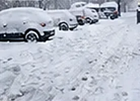 Parkering täckt av snö före snöröjning